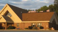 a large brick building with grass in front of a house