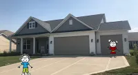 a group of people flying kites in front of a house