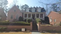 a large brick building with grass in front of a house