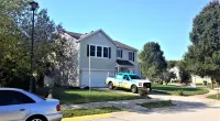 a Roof It Forward truck parked in front of a house