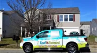 a Roof It Forward truck parked in front of a house