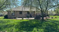 a large brick house with a lawn and trees in front of it