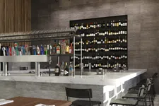 Thumbnail for Modern bar interior with marble countertop, multiple liquor bottles, beer taps, and black bar stools along the counter.