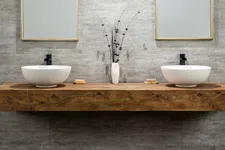 Thumbnail for Modern double bathroom vanity with white vessel sinks, wooden countertop, decorative vase, and stylish mirrors.
