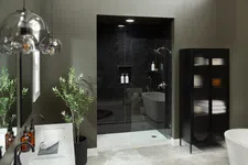 Thumbnail for Modern bathroom with glass shower, black cabinet, freestanding tub, and green plant accents in neutral tones