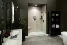 Thumbnail for Modern bathroom with glass shower enclosure, black fixtures, marble countertop, and dark cabinetry with plants.