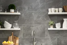 Thumbnail for Modern kitchen sink with stainless steel faucet, gray stone backsplash, white shelves with dishes and plants.