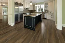 Thumbnail for Modern kitchen with dark wood flooring, black island, white cabinets, stainless steel appliances, and pendant lights.