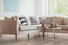 Thumbnail for Modern living room with beige sectional sofa, patterned cushions, wooden floor, and two round metal coffee tables.