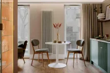 Thumbnail for Modern dining area with round white table, two wooden chairs, cozy lighting, and green kitchen cabinets.