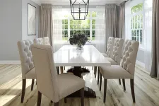 Thumbnail for Bright modern dining room with tufted beige chairs, white table, large windows, wood floor, and geometric pendant light