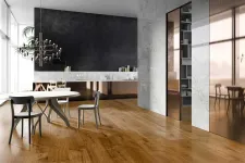 Thumbnail for Modern dining area with wooden flooring, round table, chairs, black wall, and marble accents in bright room