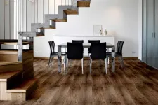 Thumbnail for Modern dining room with wooden floors, black chairs, glass table, and industrial staircase with metal railings.