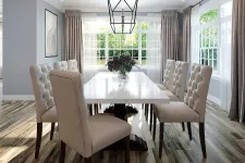 Thumbnail for Bright dining room with a white table, beige tufted chairs, wooden floors, and large windows with curtains.