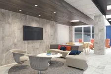 Thumbnail for Modern office lounge with beige sectional sofa, gray chairs, round table, and wall-mounted TV on tiled wall.