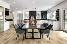 Thumbnail for Spacious modern kitchen and dining area with black marble table, gray chairs, wood flooring, and large windows.