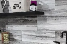 Thumbnail for Modern kitchen corner with gray stone backsplash, granite countertop, black faucet, and storage basket labeled Stuff