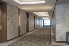 Thumbnail for Modern hotel corridor with patterned carpet, wooden doors, wall sconces, and recessed ceiling lights.
