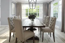 Thumbnail for Bright dining room with a wooden table, eight tufted beige chairs, large windows, and a geometric chandelier.
