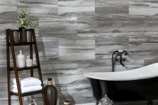 Thumbnail for Modern bathroom with a black clawfoot tub, wood shelf holding towels and decor, and gray marble wall tiles.