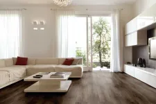 Thumbnail for Modern living room with dark wood flooring, white sectional sofa, glass chandelier, and large windows with sheer curtains