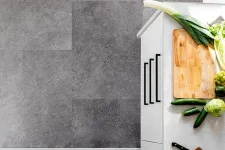 Thumbnail for Top view of a white kitchen counter with chopping board, vegetables, knife, and modern gray tile flooring