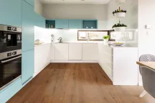 Thumbnail for Modern kitchen with blue and white cabinets, wood floor, built-in appliances, and pendant plant holders by window.