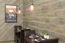 Thumbnail for Cozy restaurant corner with wooden table, leather chairs, hanging lights, and vintage train travel poster on wood panel wall.