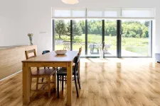 Thumbnail for Bright modern dining room with wooden table, mixed chairs, large glass doors, and natural light flooring
