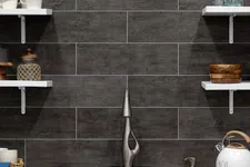 Thumbnail for Modern kitchen sink with sleek faucet, dark textured tile backsplash, white shelves with mugs and glass bottles.