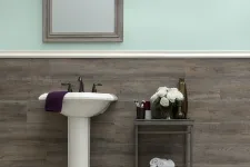 Thumbnail for Modern bathroom with pedestal sink, wooden panel wall, light mint paint, mirror, and decorative towels and flowers.