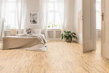 Thumbnail for Bright minimalist bedroom with large windows, white curtains, beige bedding, wooden floor, and indoor plant by doorway.