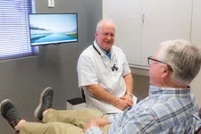 Thumbnail for Dentist consulting an elderly male patient in a bright, modern dental office with a scenic window view on the monitor.