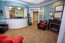 Thumbnail for Reception area of Volner Family Dentistry with seating, front desk, certificates, and calming blue walls.