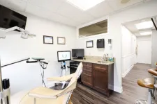 Thumbnail for Bright dental office with beige patient chair, monitors, cabinets, and certificates on the wall.