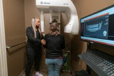 Thumbnail for Dental technician assists patient with 3D dental X-ray imaging using advanced Dexis OP 3D machine.