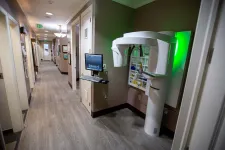 Thumbnail for Dental office hallway with a panoramic dental X-ray machine and computer workstation on the wall.