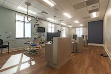 Thumbnail for Modern dental clinic interior with treatment chairs, monitors, wood flooring, and ocean-themed wall decals.