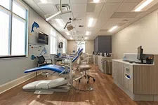 Thumbnail for Bright dental office with blue chairs, marine-themed wall art, wood flooring, and modern dental equipment.