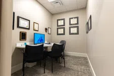 Thumbnail for Small professional office with computer, two chairs, beige walls, and framed certificates on the walls.