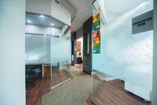 Thumbnail for Modern office hallway with frosted glass consultation rooms and wooden flooring in a professional setting