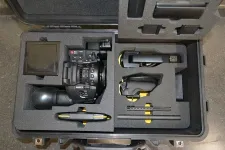 Thumbnail for Hard case with foam inserts holding a Canon video camera and accessories for secure transport and protection.
