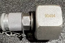Thumbnail for Metal hydraulic quick connect coupling with protective cap and chain on textured black surface.
