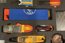Thumbnail for Set of Klein Tools including wire strippers, crimpers, multimeters, and measuring tape in foam case