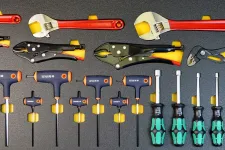 Thumbnail for Set of various hand tools including adjustable wrenches, locking pliers, T-handle hex keys, and screwdrivers organized on a gray surface.
