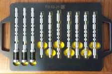 Thumbnail for Set of metal lock pick tools with cylindrical shapes arranged neatly in a black tray on wooden surface.