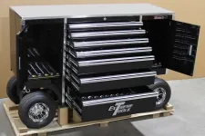 Thumbnail for Black mobile tool chest with multiple open drawers and wheels on a wooden pallet indoors.