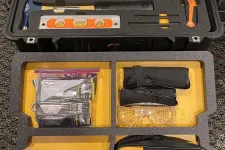 Thumbnail for Organized toolkit case filled with hand tools, safety glasses, level, hammer, and Fluke branded bag on yellow foam insert.