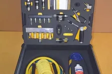 Thumbnail for Open black toolbox with yellow coiled hose and various pneumatic tools and accessories on foam insert.