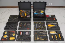 Thumbnail for Complete professional tool kit with various hand tools neatly organized in black carrying cases on a tiled floor.